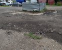 Дорога у площадки ТКО и территория за самой площадкой. Пару десятков лет назад большое пространство перед площадкой ТКО (на первом фото) было асфальтировано. Асфальт со временем пришел в негодность, ремонтные работы на этом участке никогда не проводились, хотя это одна из дорог к 1 школе, к техникуму, проезжая часть и по совместительству подход к площадке ТКО. Недавно участок перед ТКО и за площадкой ТКО посыпали асфальтобетонным ломом, как временное решение. Просим организовать укладку асфальта на этой проезжей части, перед ТКО и убрать остатки асфальтобетоного лома за ТКО, асфальтировав пространство вокруг мусорной контейнерной площадки.