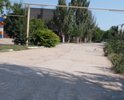 Разбитая дорога по ул. Десантников в пгт. Приморский. Старый асфальт, ямы. Отсутствует освещение и ливневая канализация. Также в плохом состоянии тротуар.
