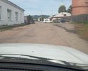 На перекрестке Коммунальной улицы разрушение полотна асфальтового. Проезд затруднен сильно. Ямы, выбоины, бугры, куски асфальта. Уклон со стороны Церкви примерно 6 градусов.Сам проезд имеет ложбину асфальтовую требующую асфальтирования ( делался для стока воды с водонапорной башни стоящей рядом). Водосток необходим асфальтовый в стороне от дороги. Место имеется для этого.Асфальт разуршается частично требуется асфальтирование.