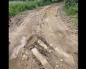 Недавно был «ремонт» дороги, во время которого насыпали глины и крупных камней размером с волейбольные мячи, всё выглядело относительно ровно, до первого дождя. Дорога стала мягкая, машины проваливаются, буксуют, застревают. Ходить пешком стало невозможно, ноги так же проваливаются под весом человека на 10-20 см. Дороги как таковой нет.
