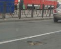 Рыленкова, возле остановки трамвая, средняя полоса перед светофором,  направление - в сторону Проспекта строителей, глубокая яма с острыми краями, проезду мешает, объезжают