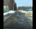 Остатки асфальта советских времён. Каждый месяц пускают грейдер сравнять ухабы. Дорога сквозная ещё на три улицы ездят все. С детьми с коляской идти просто невозможно.