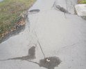 Ямы и провалы асфальтового покрытия на тротуаре.