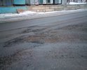 Ямы на проезжей части дороги по Нижне-Ростинскому шоссе. Полностью перекрывают одну из полос в месте примыкания второстепенной дороги с пересечением железнодорожного переезда, напротив "Исправительной колонии N 17" (ул. Угольная База, 9, в городе Мурманск).