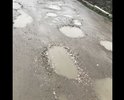 Органы муниципалитета отвечают за качество дорог местного назначения. Это указано в законе №131-ФЗ от 06.10.2003 ч.1, ст.14, п. 5. Уведомляю Вас, что дорожное покрытие ул. Полковая (в указанном месте на карте)не соответствует ГОСТ Р 50597-93 Автомобильные дороги и улицы. Требования к эксплуатационному состоянию, допустимому по условиям обеспечения безопасности дорожного движения. Имеются ряд дефектов в виде ямы, выбоин, келейности (зазоры под рейкой КОНДОР выше допустимых значений явно не вооруженным златом) которые снижают безопасность движения. Также не обеспечен водоотвод с проезжей части (кюветы просто отсутствуют). Как специалист с дорожным образованием, прошу Вас рассмотреть в кратчайшие сроки данный вопрос и устранить данные дефекты путём ремонтного профилирования покрытия с добавлением нового материала с полным соблюдением технологии устройства щебеночных покрытий, а не просто пригнать грейдер и нарисовать что мы тут были. Речь идёт за отсыпку дорожной одежды из щпс с уплотнением. Надеюсь на понимание. Фото дефектов прилагаю. Также хочу получить письменный ответ с указанием точных сроков устранения дефектов, а не размытые ответы, что нет материала, как только так сразу
